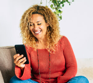 Woman smiling with phone menopausia online consultas menopausia y consejos