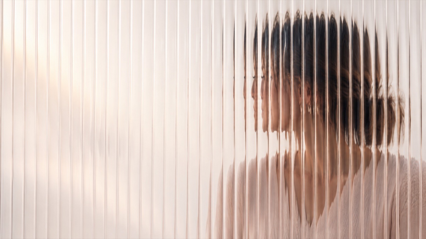 Mujer vista a través de un vidrio texturizado que difumina su rostro — la niebla mental en la menopausia